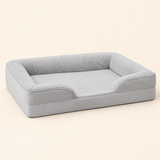 Gray raised-bolster dog bed on a warm ivory studio background
