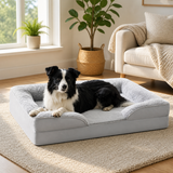 Black and white dog resting in the gray bolster dog bed