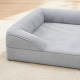 Close view of the gray bed plush surface, side bolster, and piping
