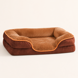 Brown raised-bolster dog bed on a warm ivory studio background