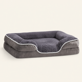 Gray raised-bolster dog bed on a warm ivory studio background